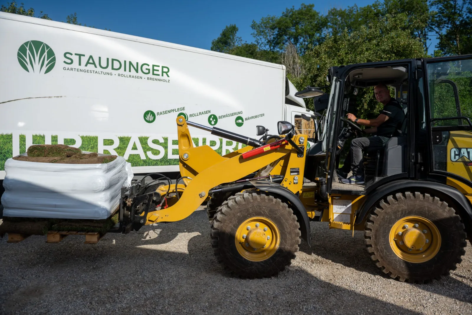 Radlader mit Rollrasen vor dem Staudinger-Lkw